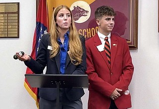 Lake Hamilton High School student Sarah Humphries, left, who serves as state Technology Student Association president, talks about what her organization does as LHHS student and 1st vice president for the Arkansas Family, Career, and Community Leaders of America, Colten Quebedeaux, looks on. (The Sentinel-Record/Brandon Smith)